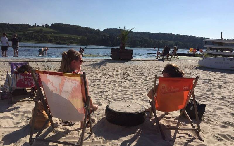 Zwei Frauen sitzen in Liegestühlen am Strand vom Seaside Beach am Baldeneysee in Essen