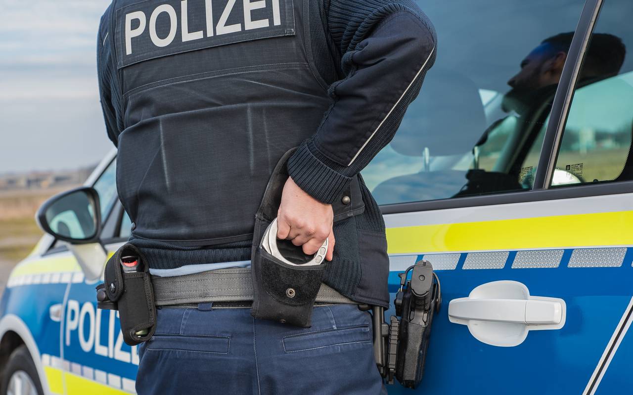 Ein Polizist nutzt Handschellen zur Festnahme (Symbolbild).
