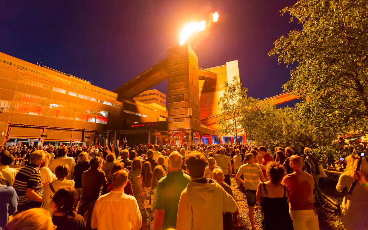 Viele Besucher schauen einer Feuershow bei der Extraschicht auf Zollverein in Essen zu.