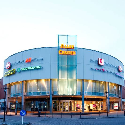 Ein großes rundes Shoppingcenter im Stadtteil Altenessen mit viel Leucht-Reclame der Geschäfte.
