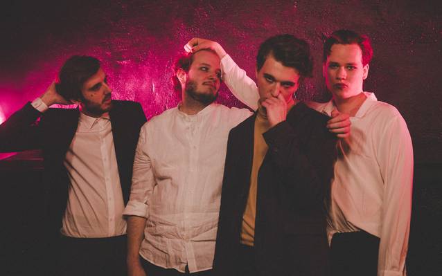 Vier Jungs der Band DOTE aus Essen vor einem violetten Hintergrund.