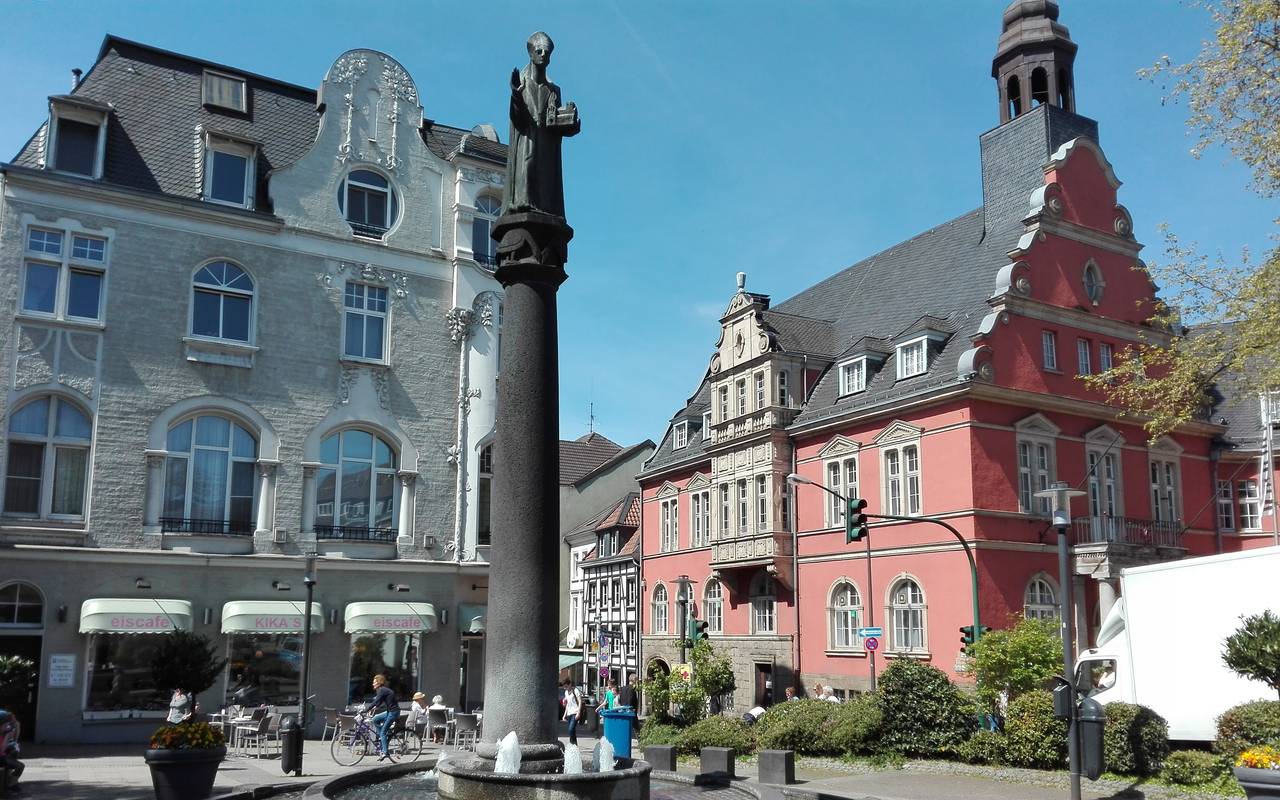 Ein Brunnen mitten im Stadtteil Werden an einer Eisdiele und Straßen.