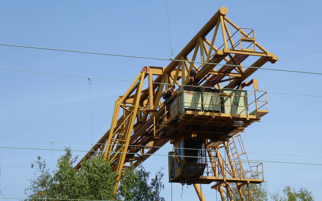 Großer gelber Kran ragt über Bäume am ehemaligen Recyclinghof Richter in Kray.