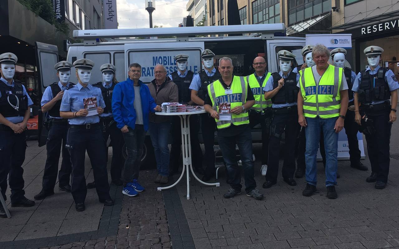 Die Polizei Essen warnt in weißen Masken mit einer Aktion vor Trickbetrügern an der Marktkirche.