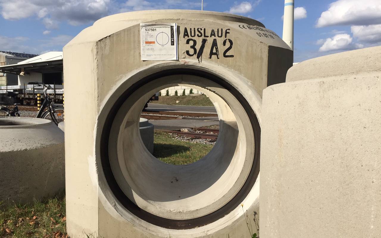 Auf dem Bild ist ein großes Stück Rohr, das auf dem Gelände von Trimet verbaut wird.