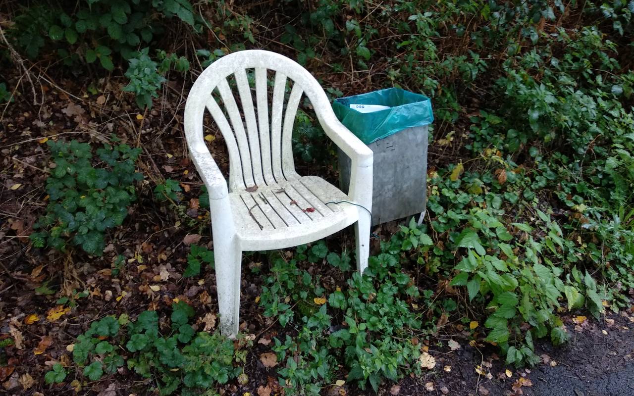 Gartenstuhl neben einem Mülleimer
