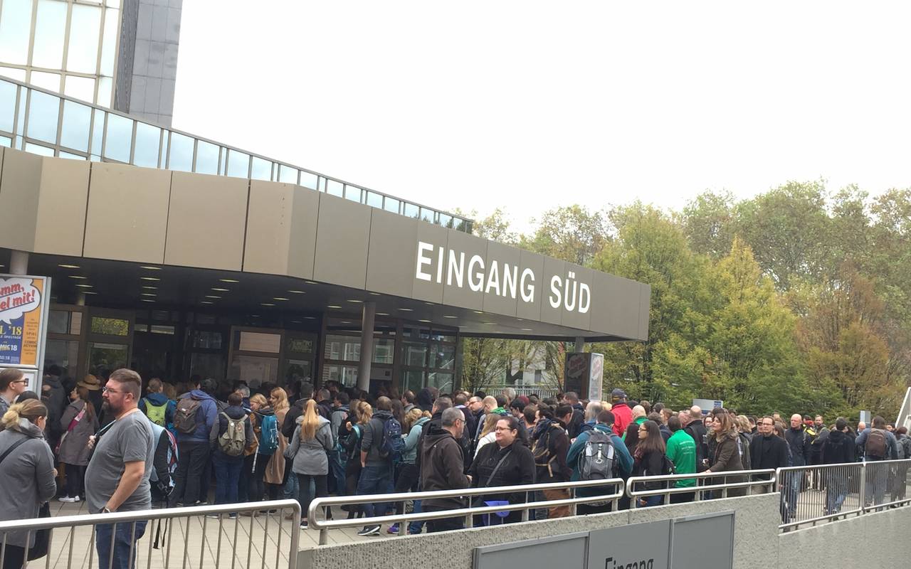 Menschen warten an der Kasse, um in die Spielemesse zu kommen.