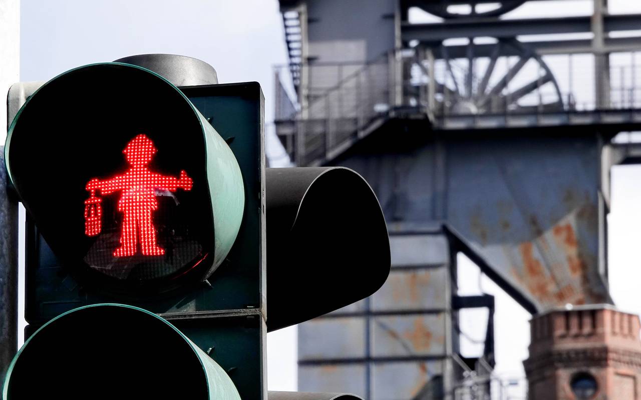 im Vordergrund ist eine Ampel mit Bergmann-Ampelmännchen. Sie steht in Bottrop, in der Nähe des Malakoffturms.