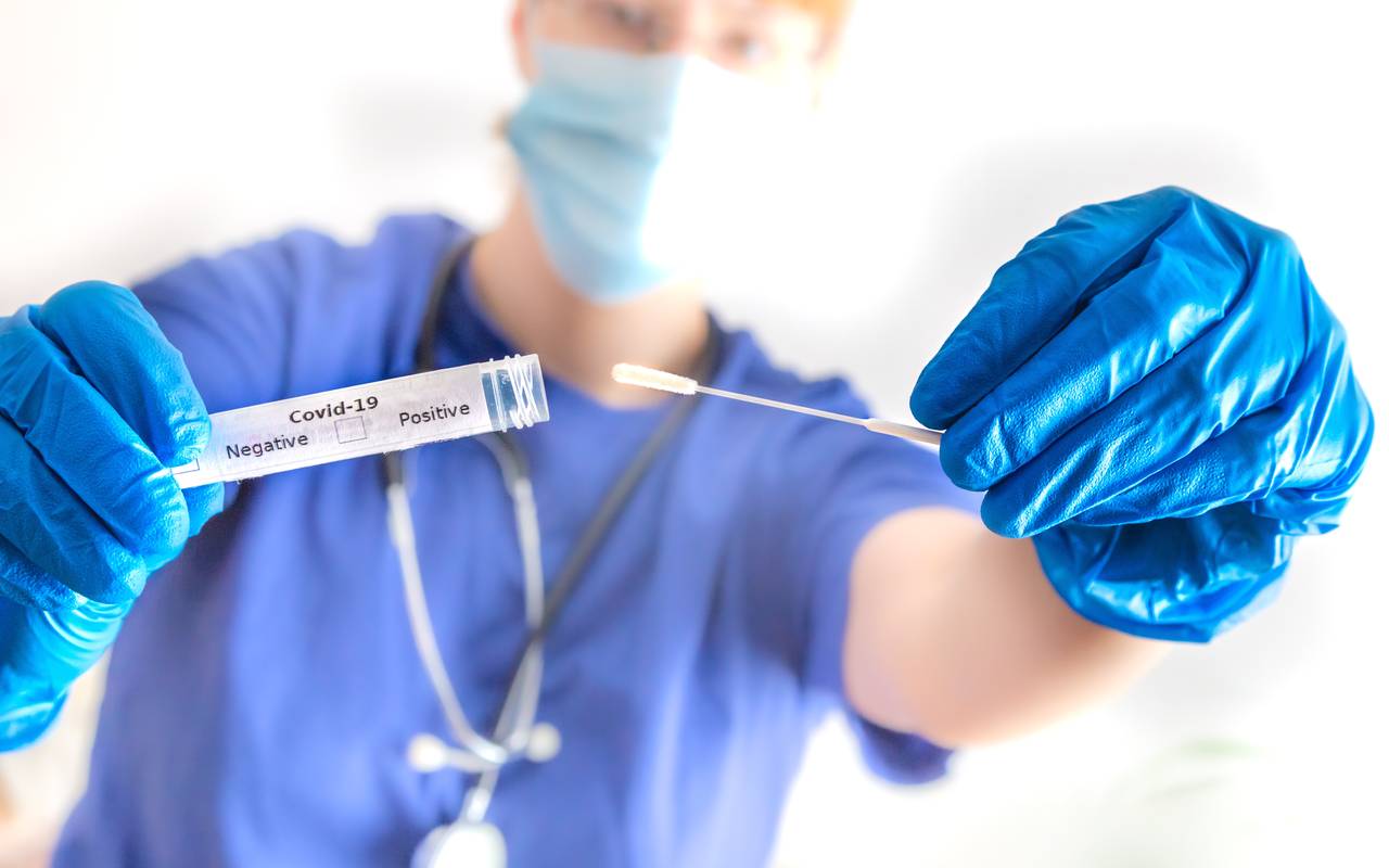 Ein Arzt hält eine Coronavirus-Abstrichröhre in der Hand.