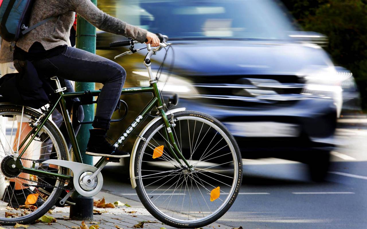 Fahrrad und Auto im Straßenverkehr an Ampel