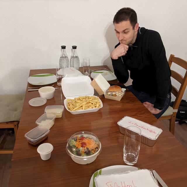 Martin sitzt am Tisch und möchte die Pommes probieren