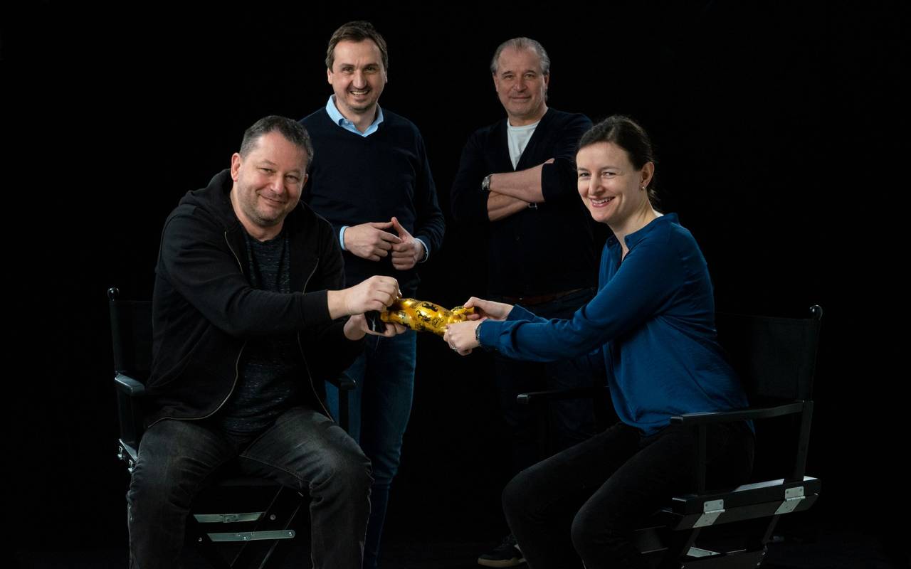 Der Essener Imagefilm "Das goldene Stadttor" hat Gold bei einem Internationalen Filmwettbewerb bekommen. Die Beteiligten stehen bei einem Foto versammelt vor einer schwarzen Leinwand.