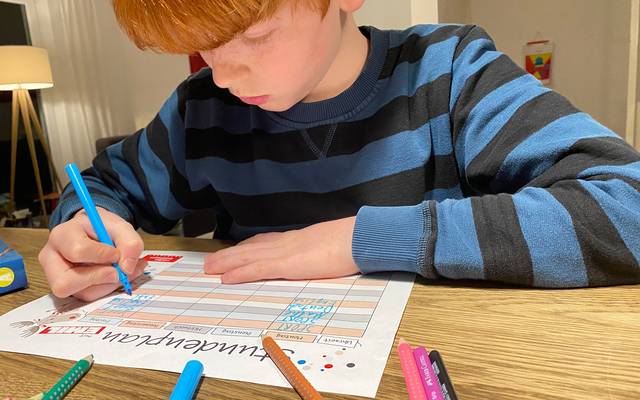 Junge füllt Stundenplan aus