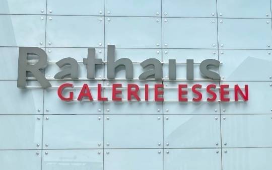 Rathaus Galerie Centermanager Frederik Westerhoff steht vor dem Haupteingang und zeigt auf das Einkaufszentrum