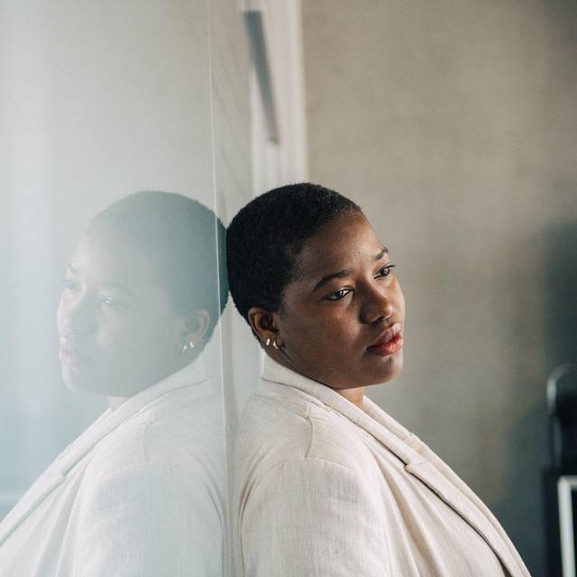 Eine Frau lehnt nachdenklich an einer Wand