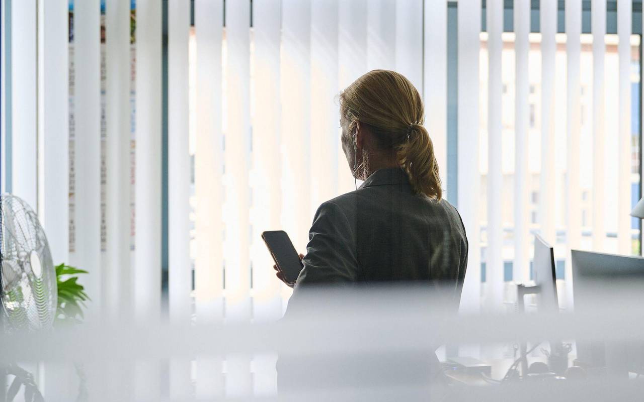Frau steht im Büro und telefoniert mit einem Headset