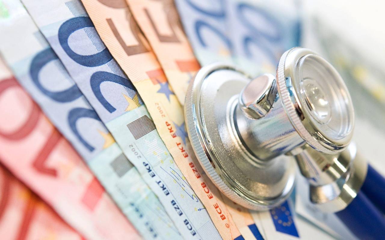 Ein Stethoskop liegt auf Geldscheinen