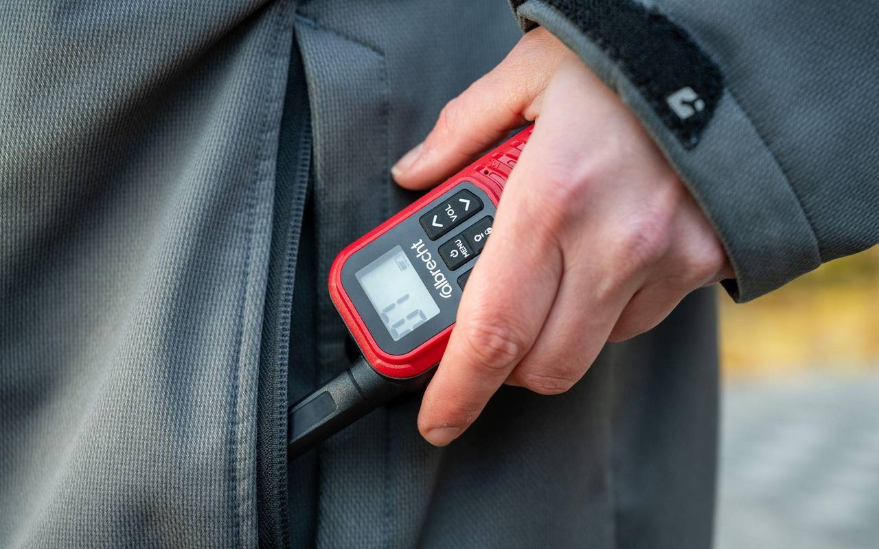 Eine Frau holt ein Walkie-Talkie aus ihrer Jackentasche