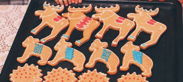 Kinder backen Weihnachtsplätzchen auf einem Blech.