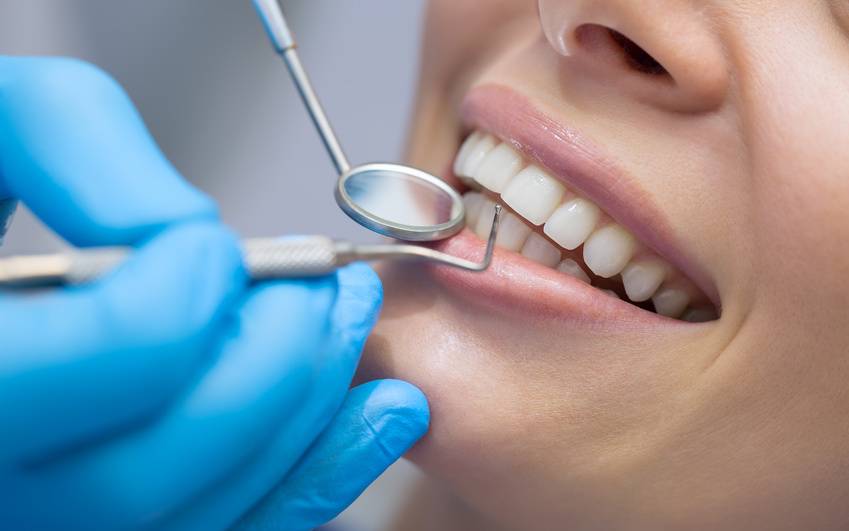 Ein Zahnarzt untersucht eine Patientin im Behandlungszimmer.