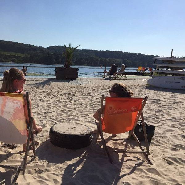 Zwei Frauen sitzen in Liegestühlen am Strand vom Seaside Beach am Baldeneysee in Essen