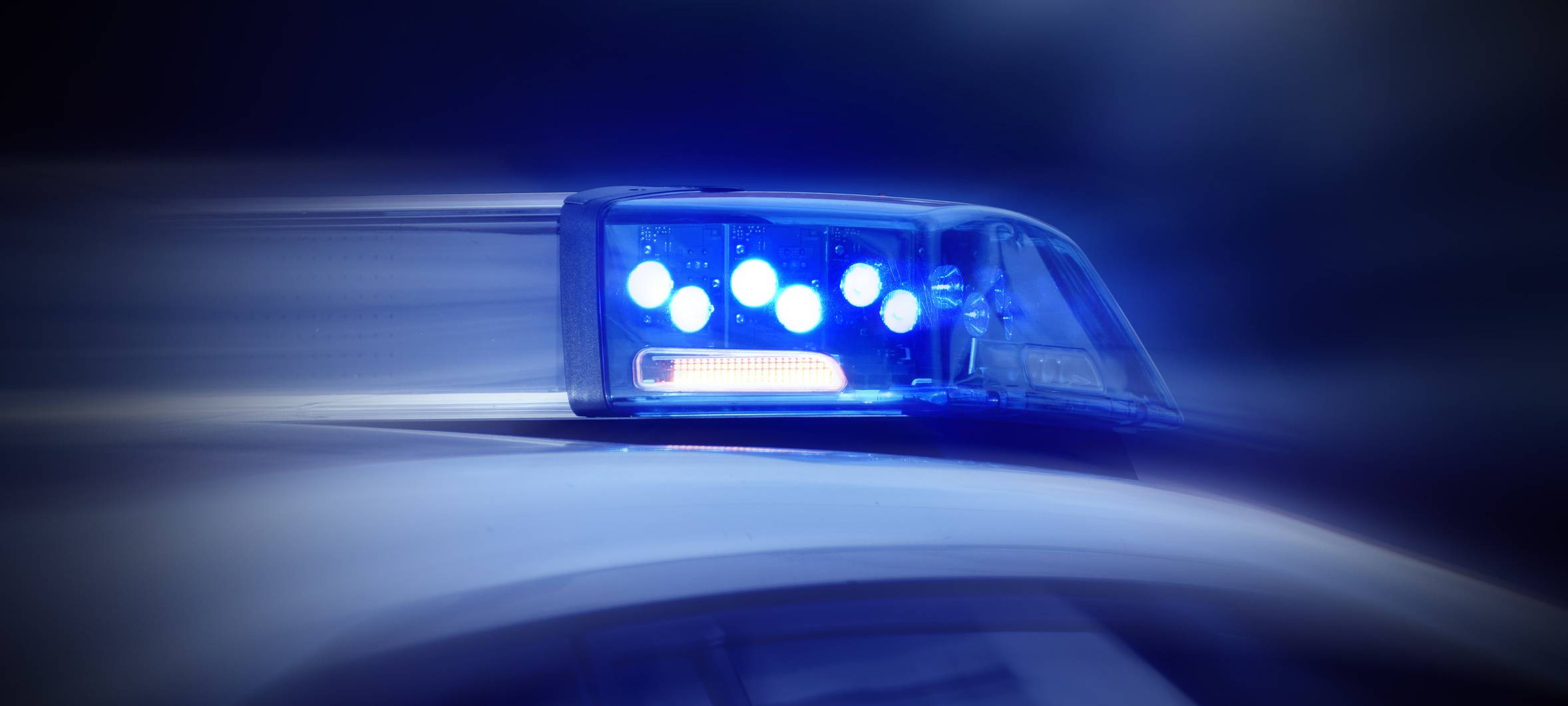 Polizeiauto mit eingeschaltetem Blaulicht in Nahaufnahme (Symbolbild).