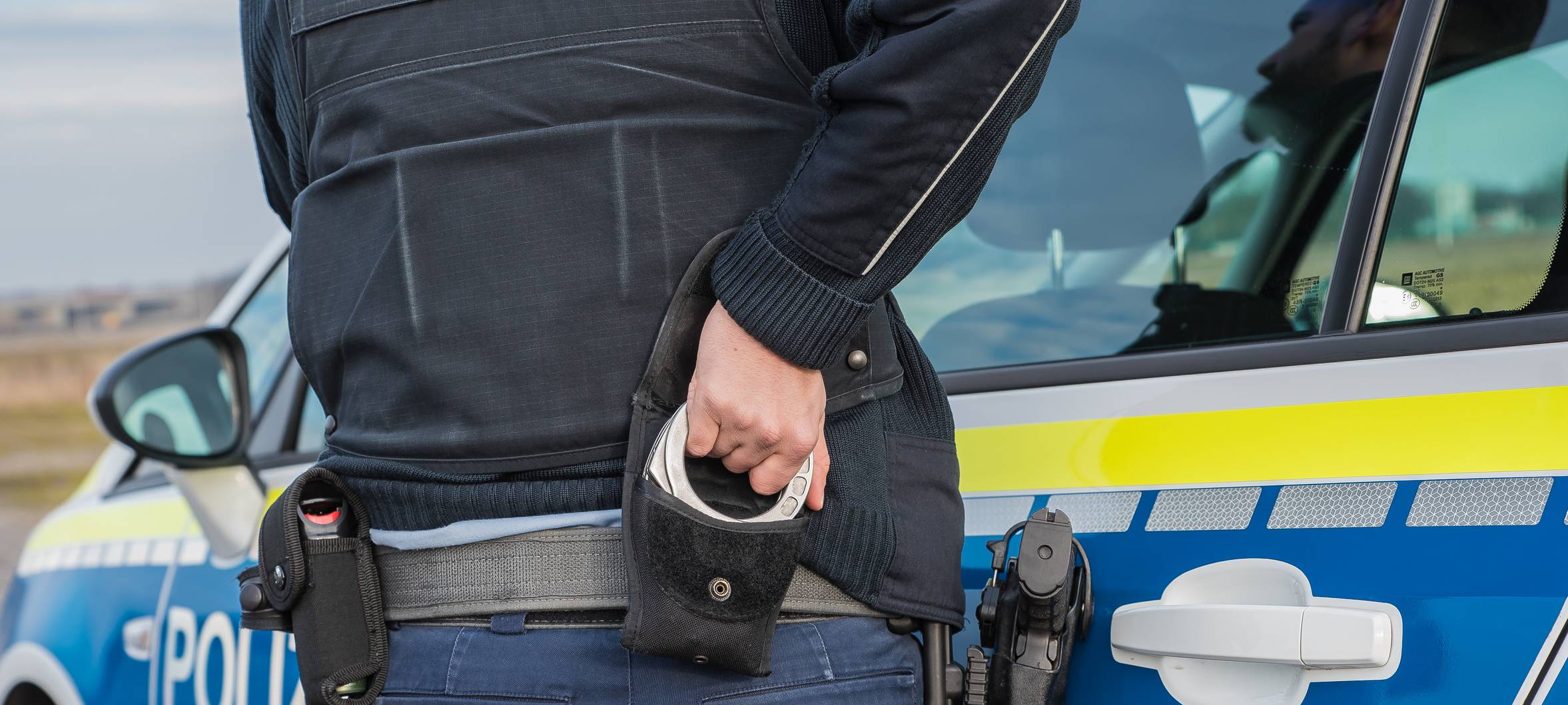 Ein Polizist nutzt Handschellen zur Festnahme (Symbolbild).