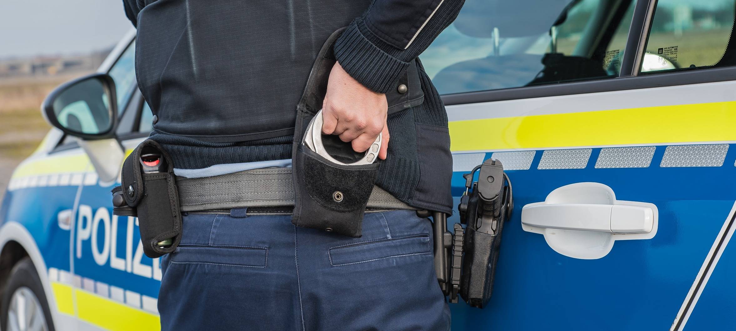 Ein Polizist nutzt Handschellen zur Festnahme (Symbolbild).