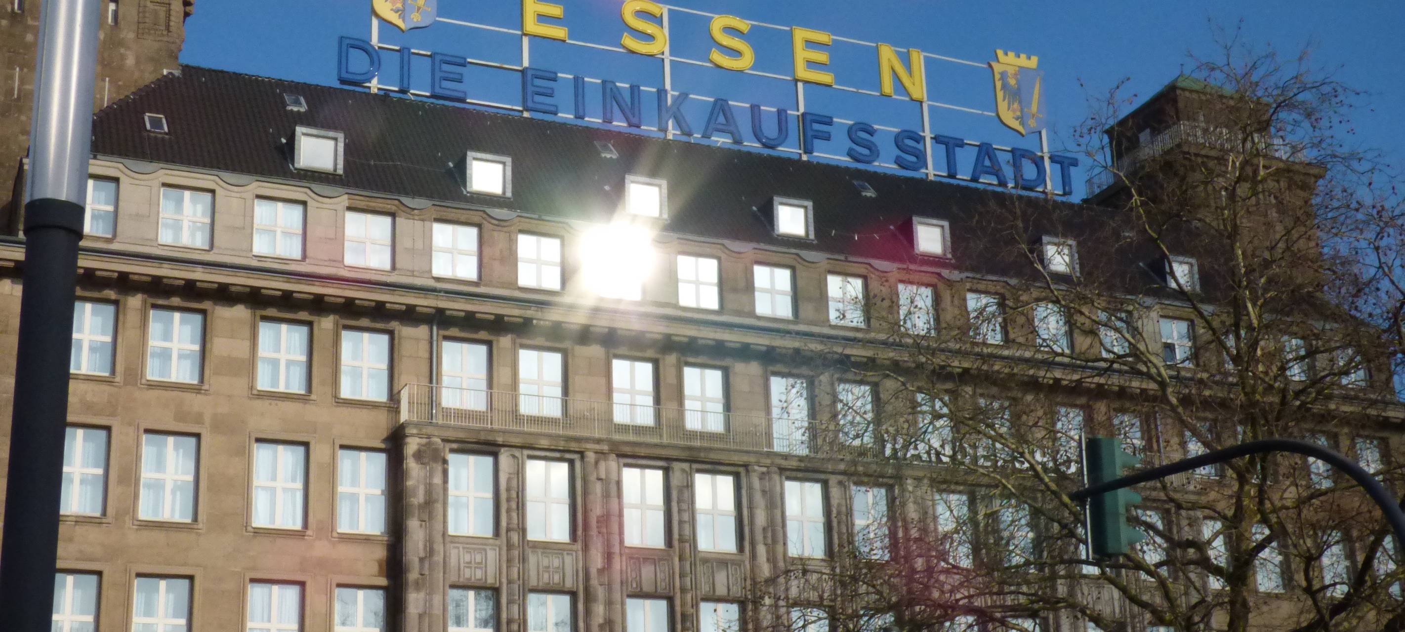 Mit blau-gelben Buchstaben steht auf einem großen Gebäude "Essen die Einkaufsstadt".