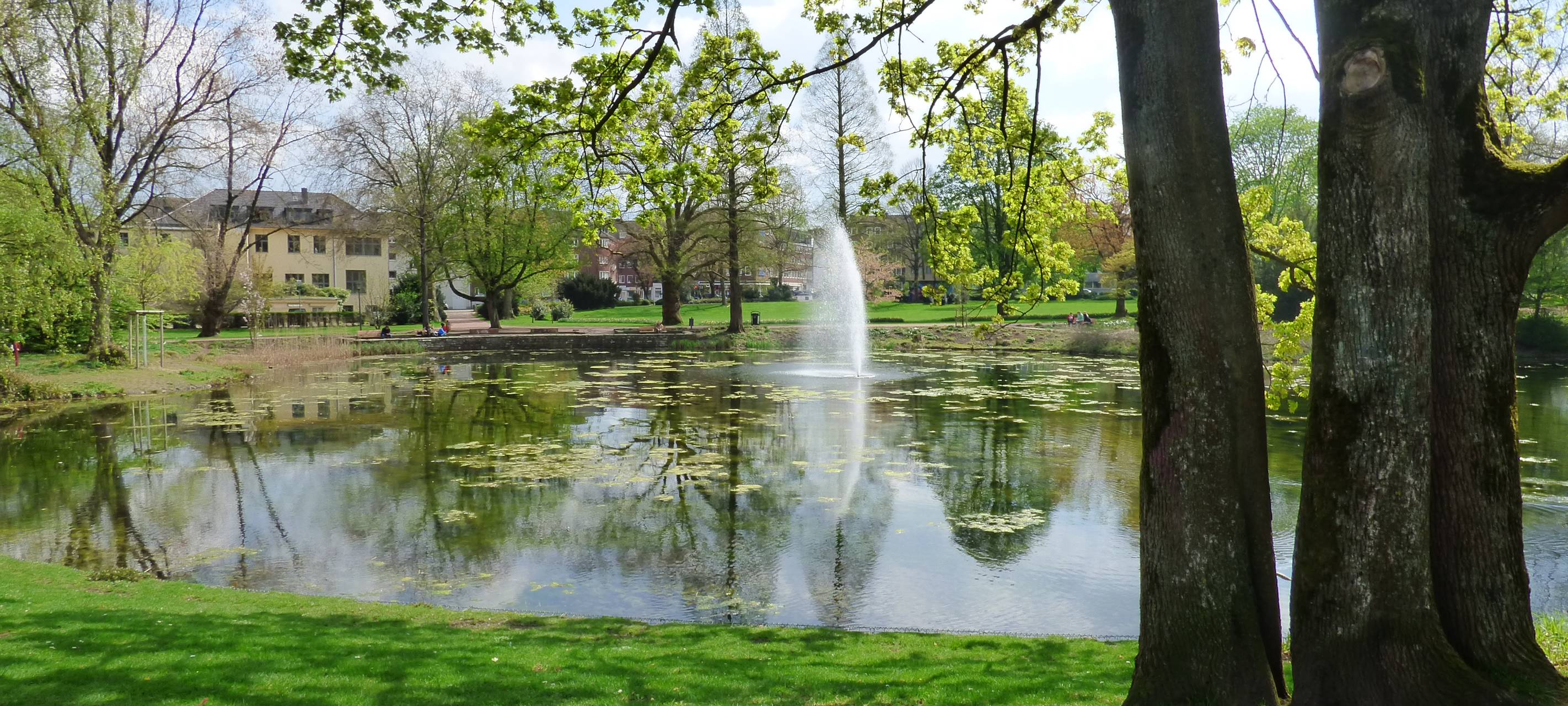 Der Stadtgarten im Essener Südviertel mit einem großen Teich und Fontäne.