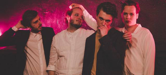 Vier Jungs der Band DOTE aus Essen vor einem violetten Hintergrund.