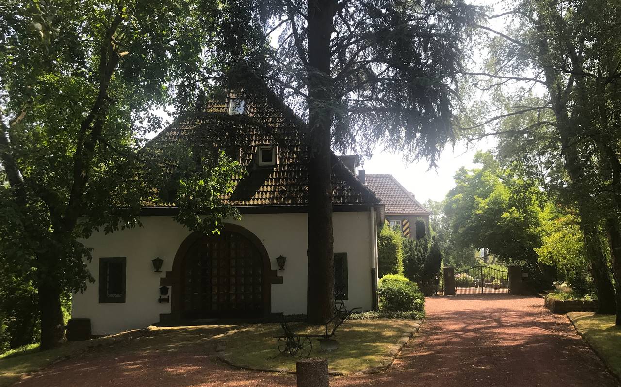 Eine weißes Haus mit rot-braunem Spitzdach mitten im Wald in Essen Horst.