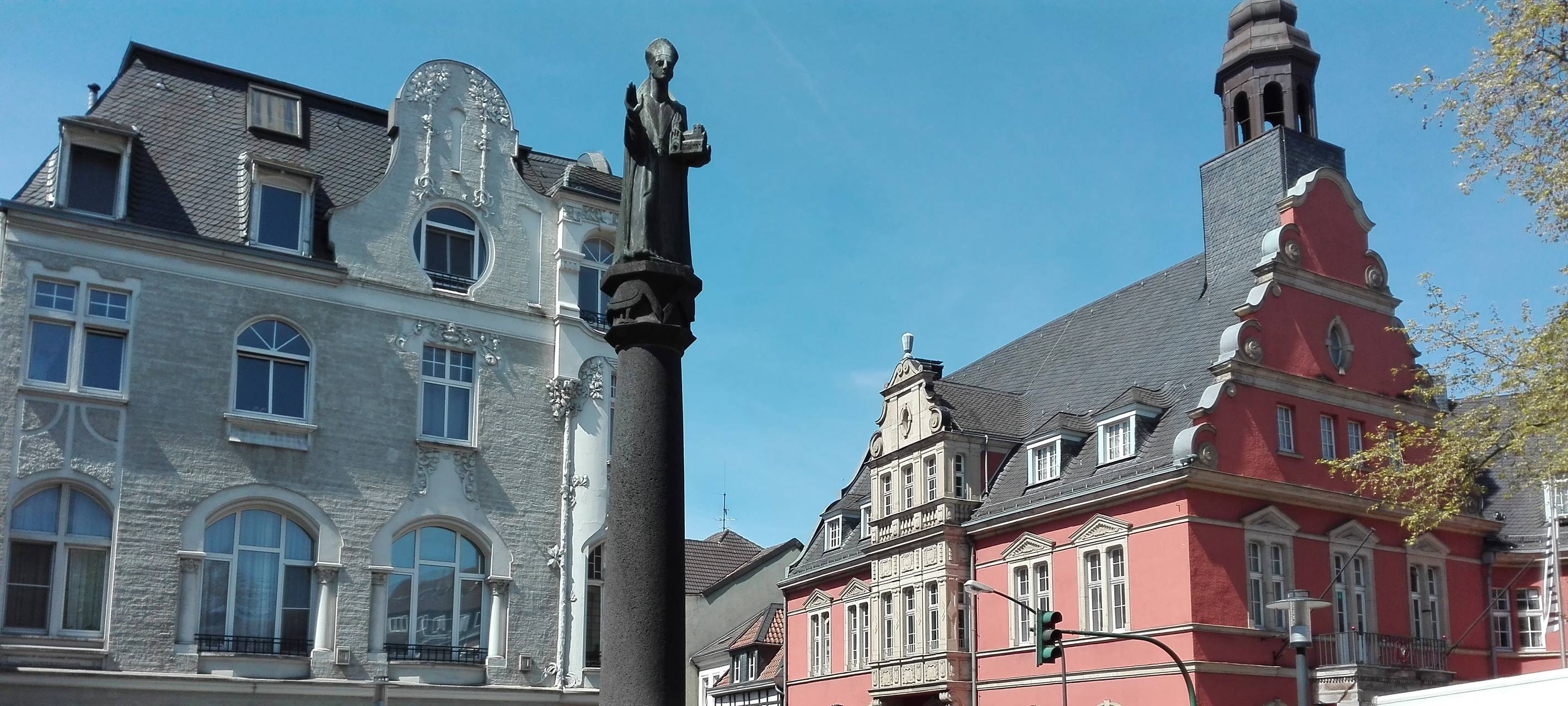 Ein Brunnen mitten im Stadtteil Werden an einer Eisdiele und Straßen.