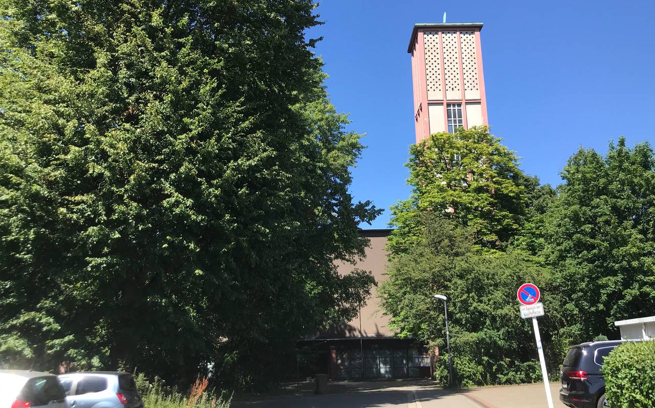 Die Pauluskirche in Essen Gerschede steht hinter Bäumen und hat einen Rechteckigen Turm.