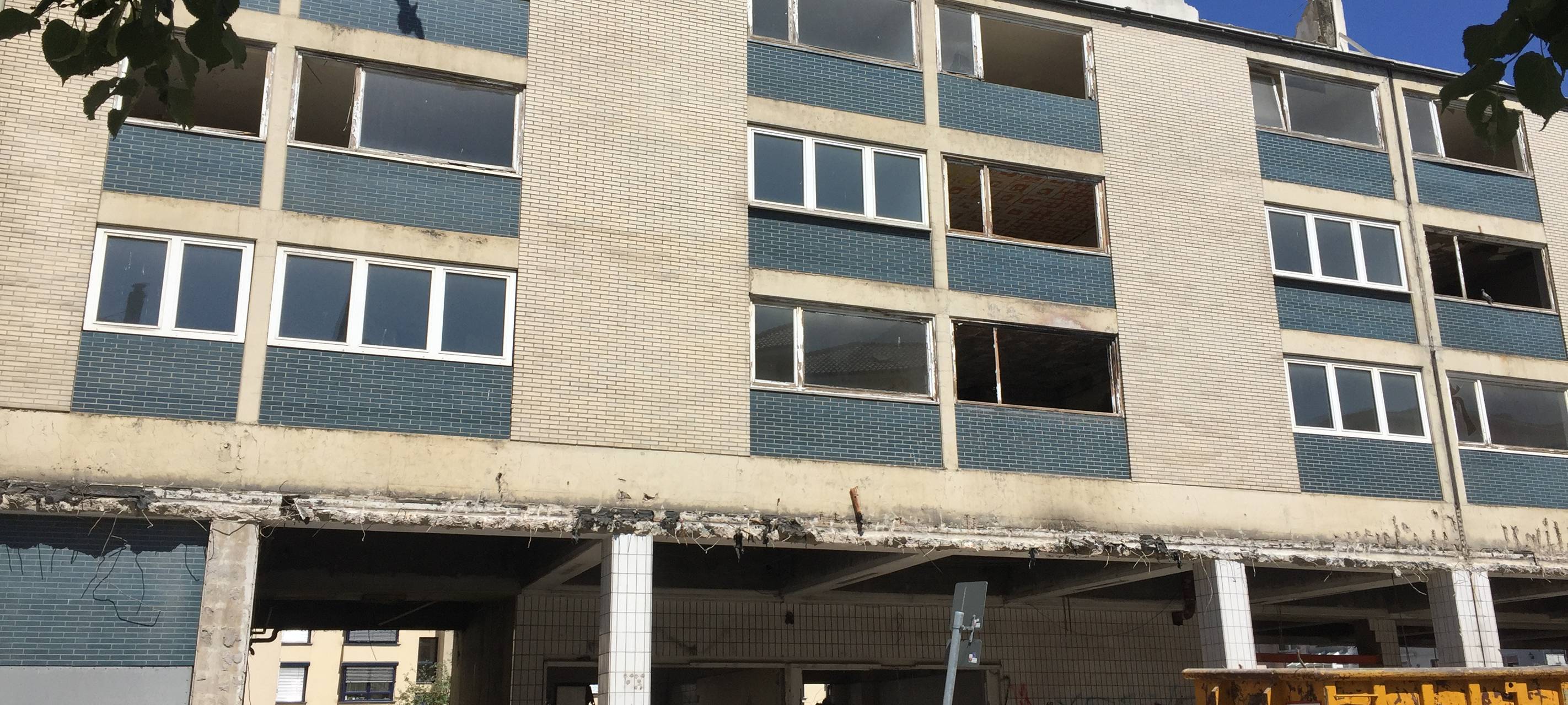Schimmi's Garage im Westviertel von Essen ist ein weißes Kachelhaus mit blauen Kacheln unter jedem Fenster. Es sieht sehr heruntergekommen aus.