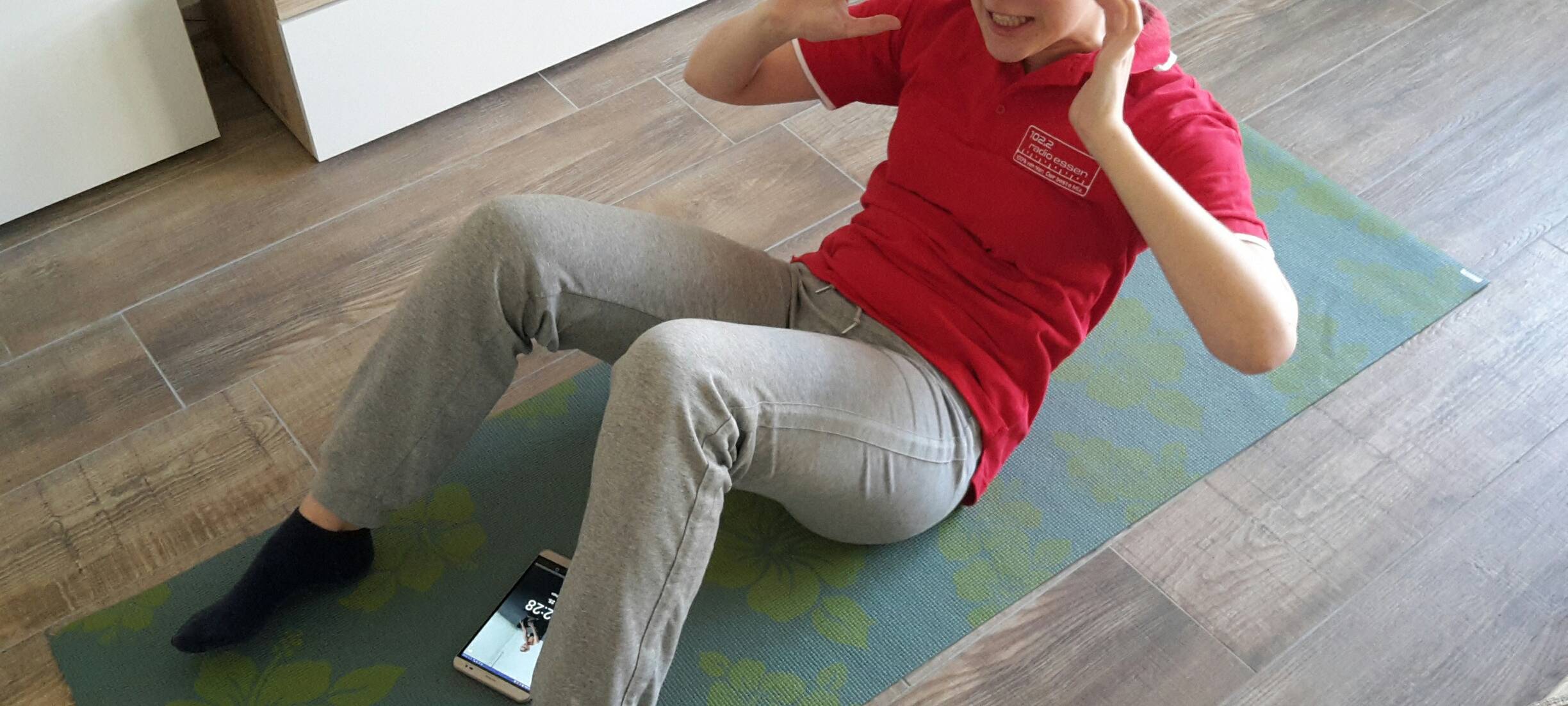Radio Essen-Moderatorin Larissa Schmitz testet auf einer Yoga-Matte eine Fitness-App.