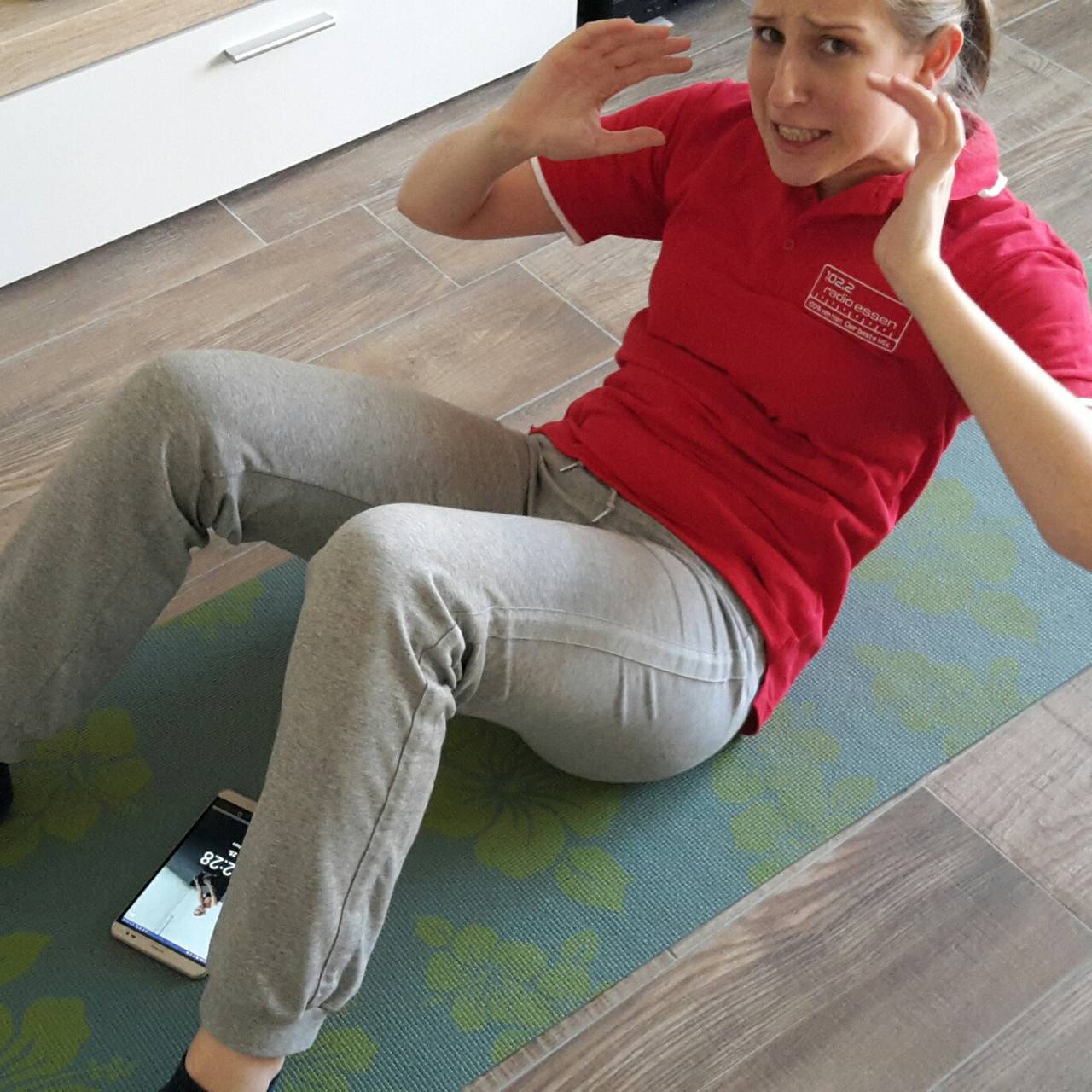 Radio Essen-Moderatorin Larissa Schmitz testet auf einer Yoga-Matte eine Fitness-App.