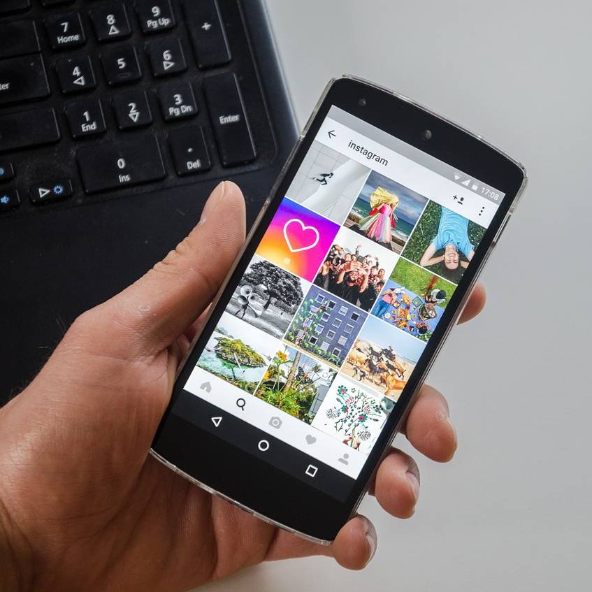 Eine Hand hält eine Handy mit Instagram