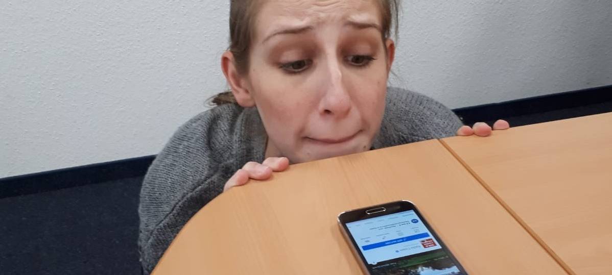Radio Essen-Moderatorin Larissa Schmitz guckt nervös über die Tischkante auf ihr Handy, weil sie die Social Media 5 Tage nicht benutzen darf.