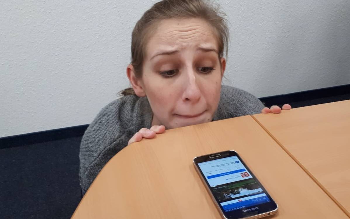 Radio Essen-Moderatorin Larissa Schmitz guckt nervös über die Tischkante auf ihr Handy, weil sie die Social Media 5 Tage nicht benutzen darf.