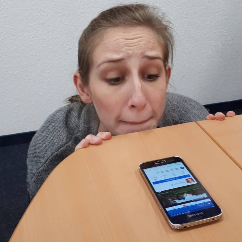 Radio Essen-Moderatorin Larissa Schmitz guckt nervös über die Tischkante auf ihr Handy, weil sie die Social Media 5 Tage nicht benutzen darf.
