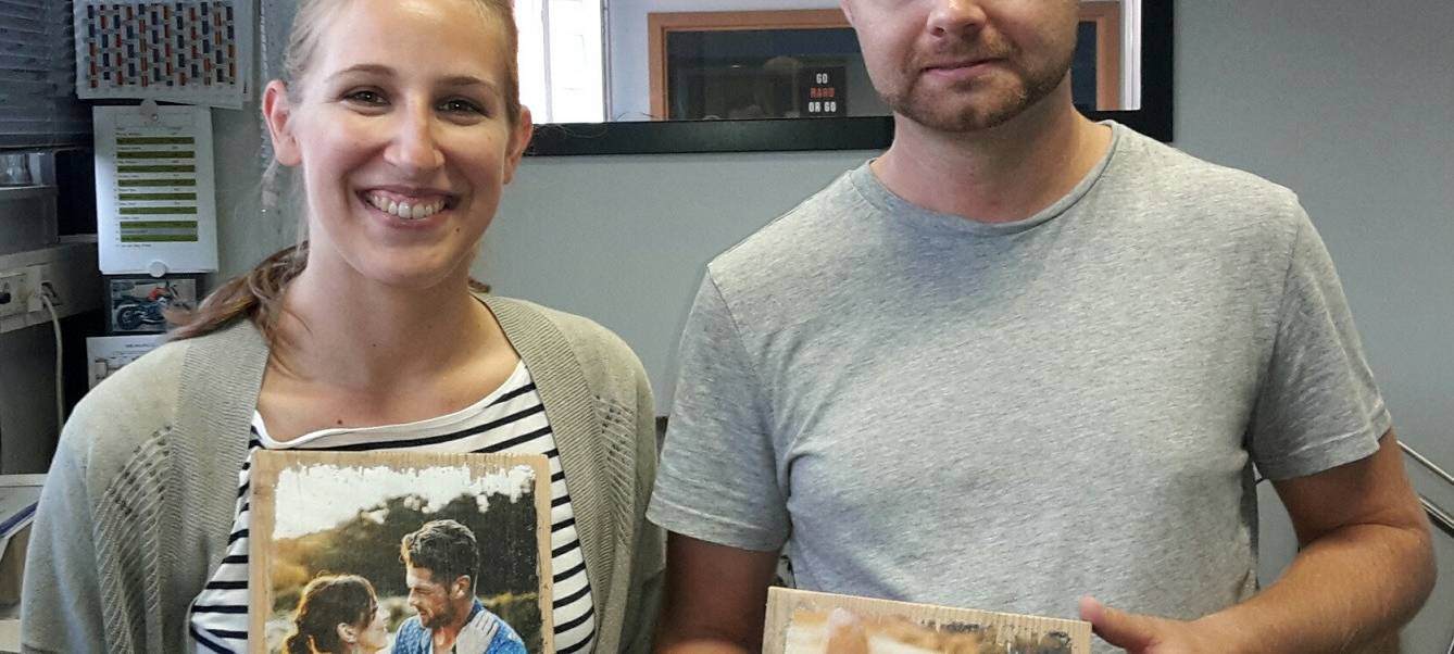 Kevin Gonska, Chef von Lumberprint aus Essen zeigt seine Fotos auf Holz mit Radio Essen-Moderatorin Larissa Schmitz.