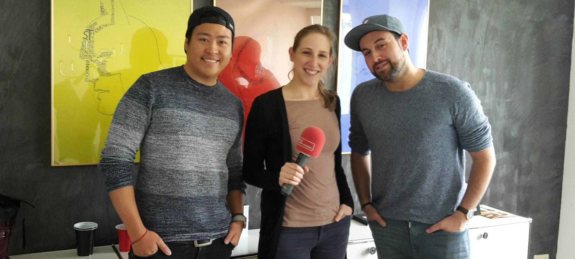 Chuong Nguyen und Genia Lewitzki und Larissa Schmitz von Radio Essen im Interview in einem Büro.