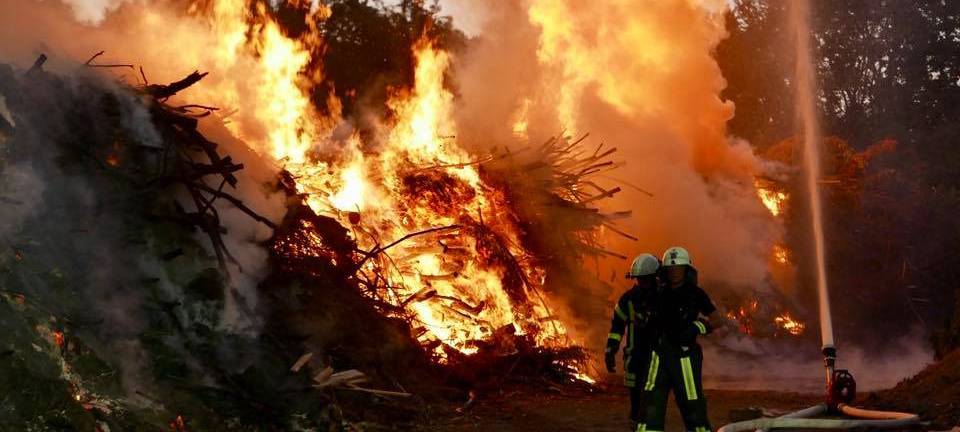 Ein Feuer auf einem Feld in Bochum mit Feuerwehr-Männern
