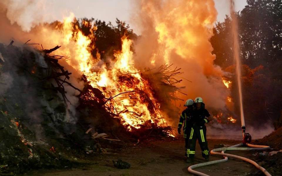 Ein Feuer auf einem Feld in Bochum mit Feuerwehr-Männern