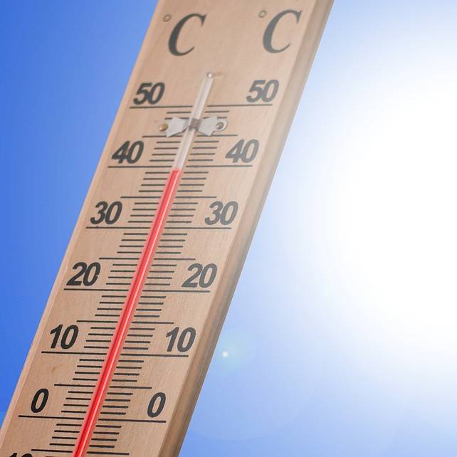 Holzthermometer zeigt 40 Grad mit knalliger Sonne dahinter