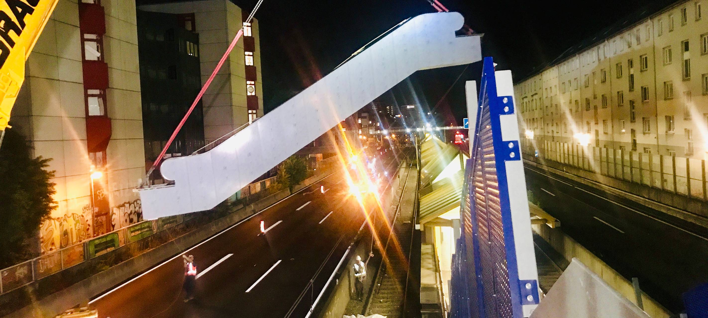 Ein Kran hebt in Holsterhausen auf der Autobahn eine Rolltreppe an die richtige Stelle