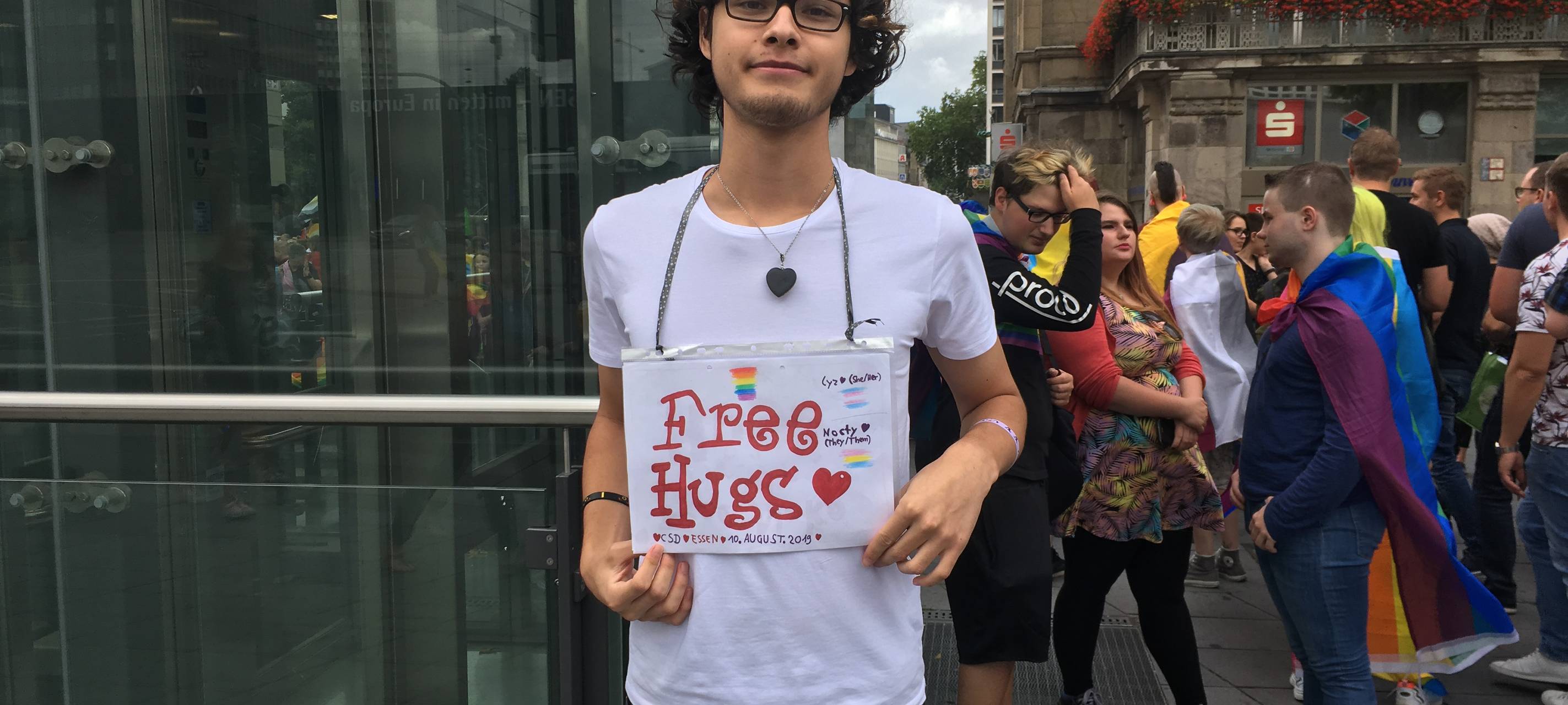 Teilnehmer mit einem "Free Hugs"-Schild