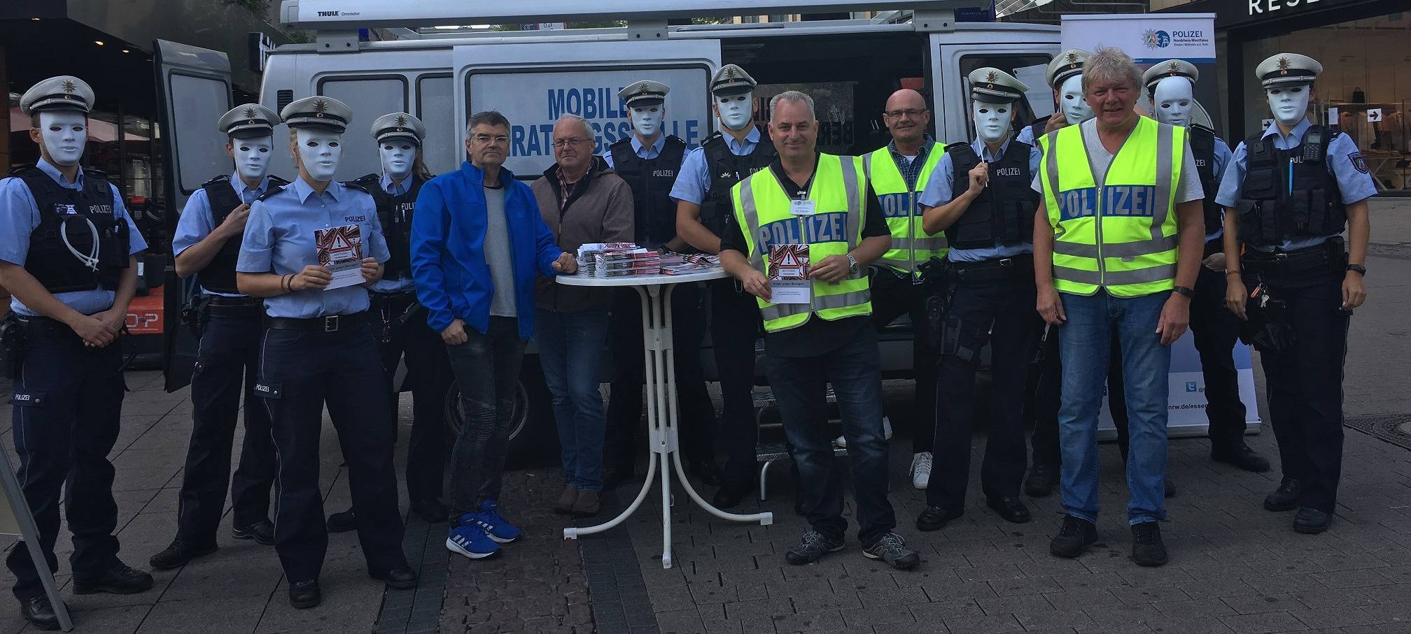 Die Polizei Essen warnt in weißen Masken mit einer Aktion vor Trickbetrügern an der Marktkirche.