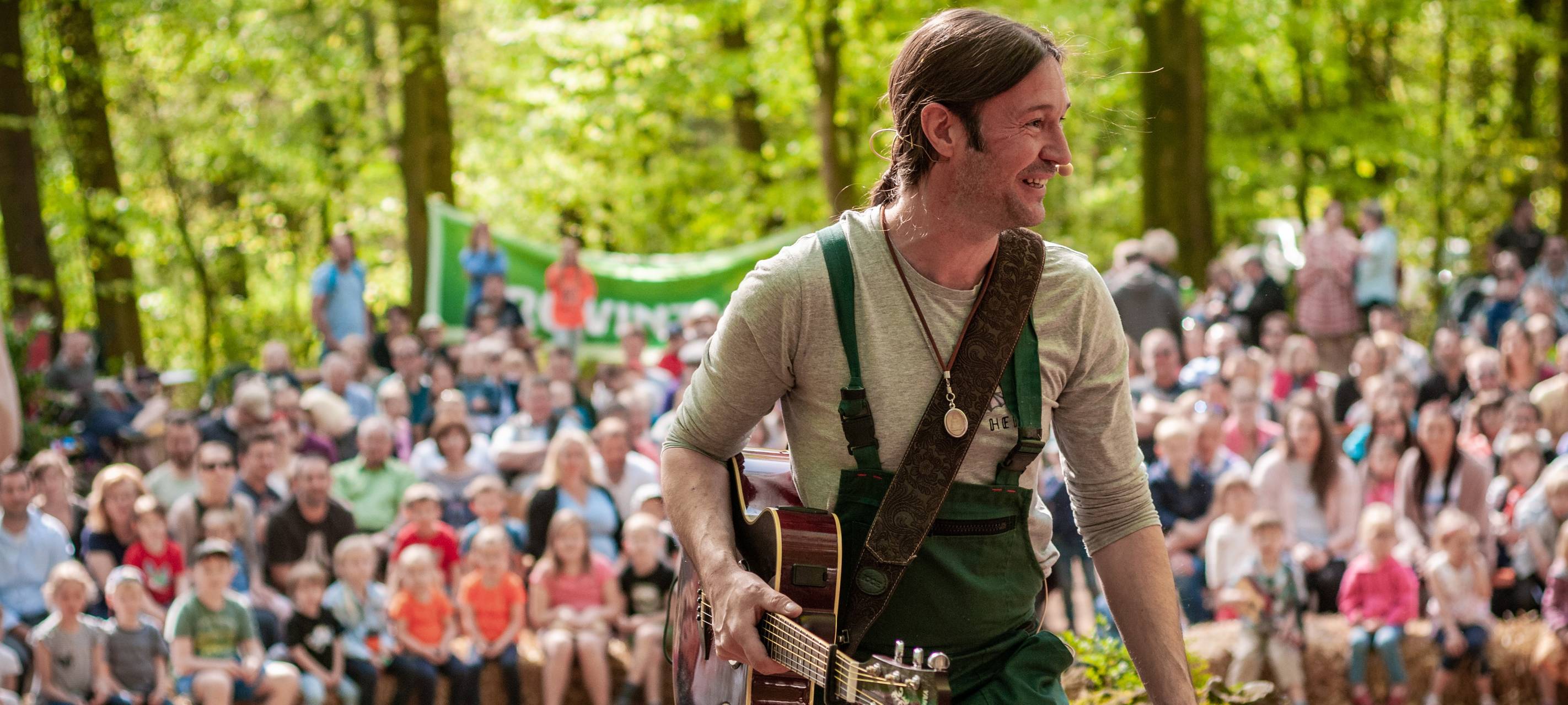 Der Essener Sänger Heiko Fänger mit Gitarre und vielen Kindern.
